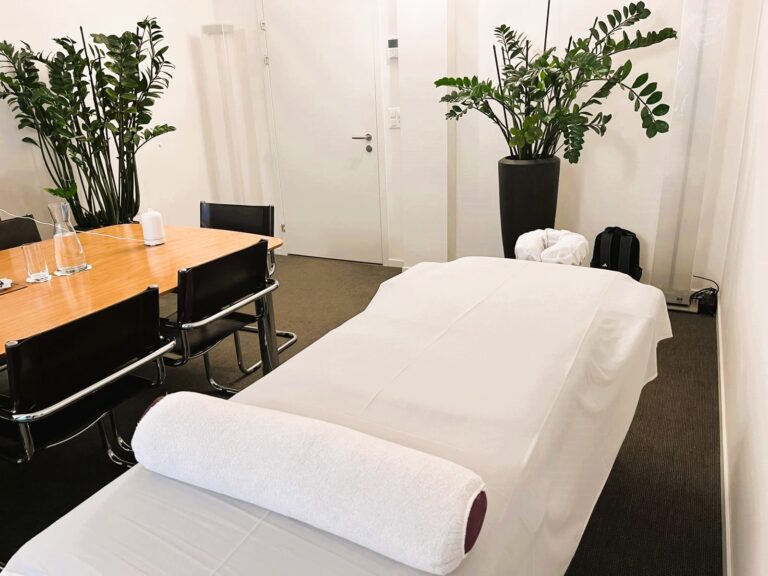 Office massage setup in a meeting room in Zurich with massage table and plants